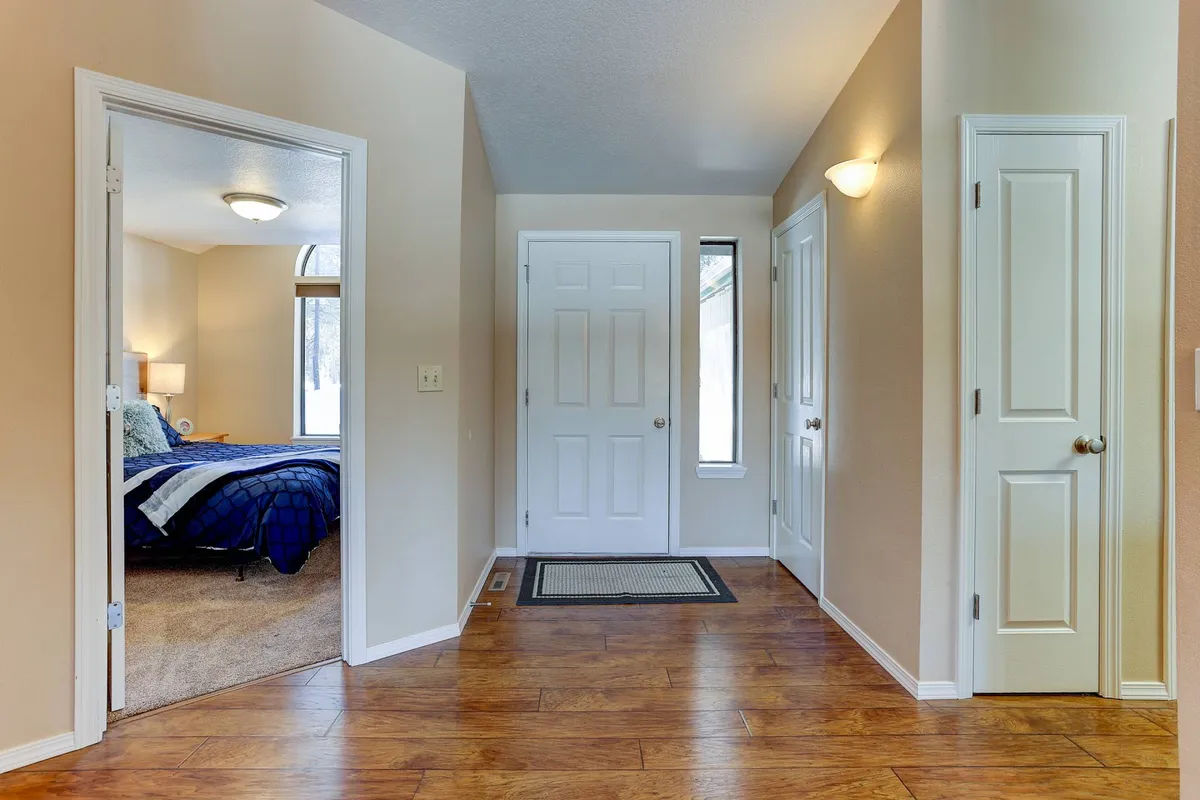 A bright entryway with a front door opening into a hallway, natural light streaming in, and clear sightlines to interior spaces. The area is uncluttered and inviting—ideal for transitioning from outside to inside.